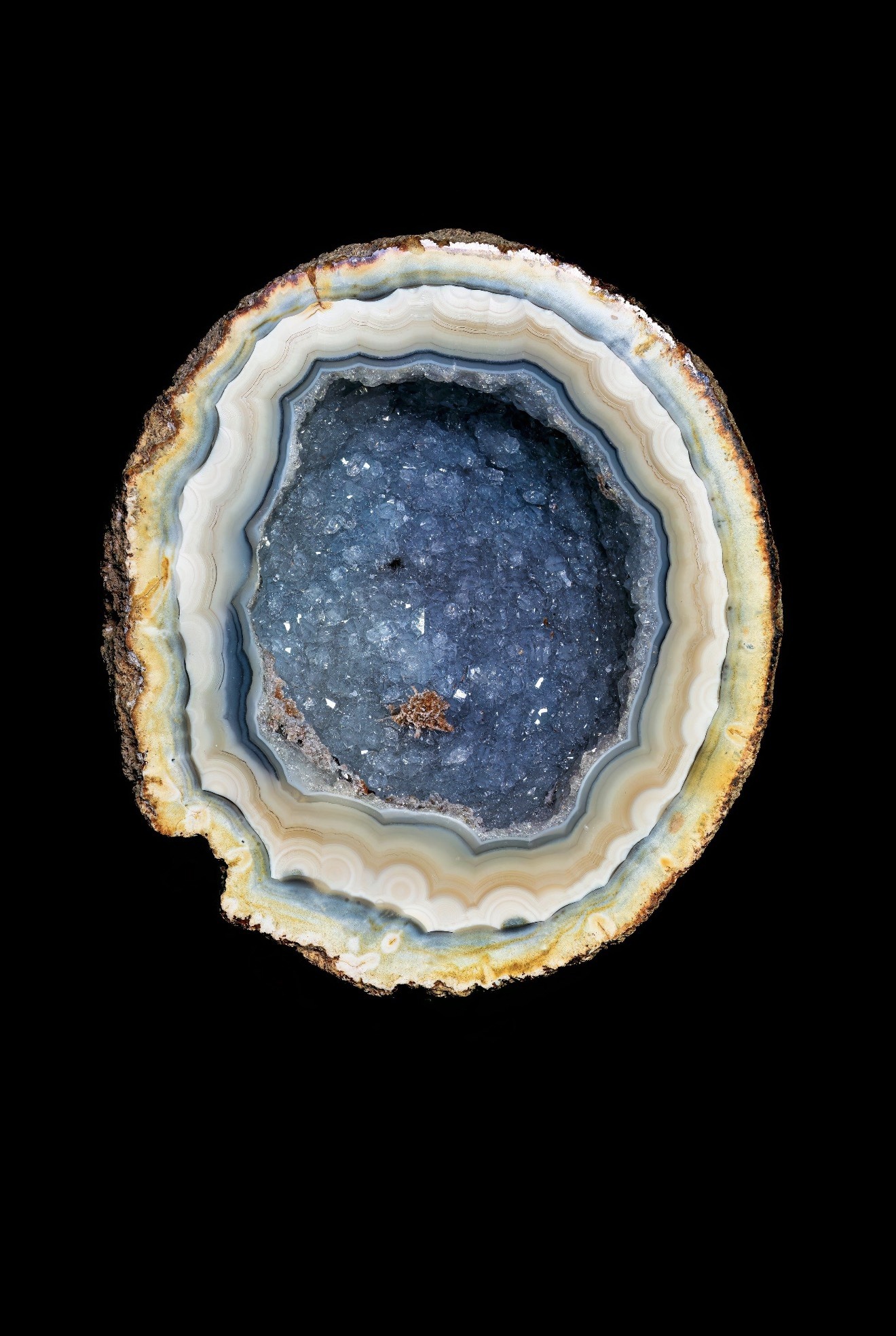 Polished agate geode half with concentric banding around a crystalline blue center