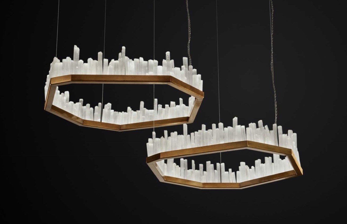 Twin hexagonal brass chandeliers crowned with clear quartz points against black